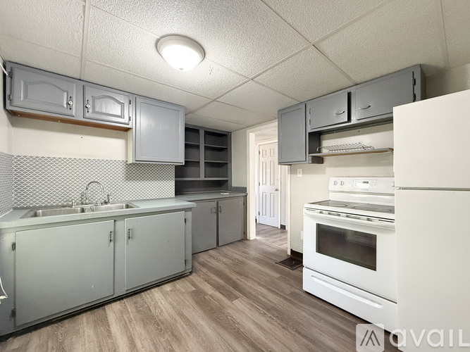 A kitchen with white appliances and grey cabinets.