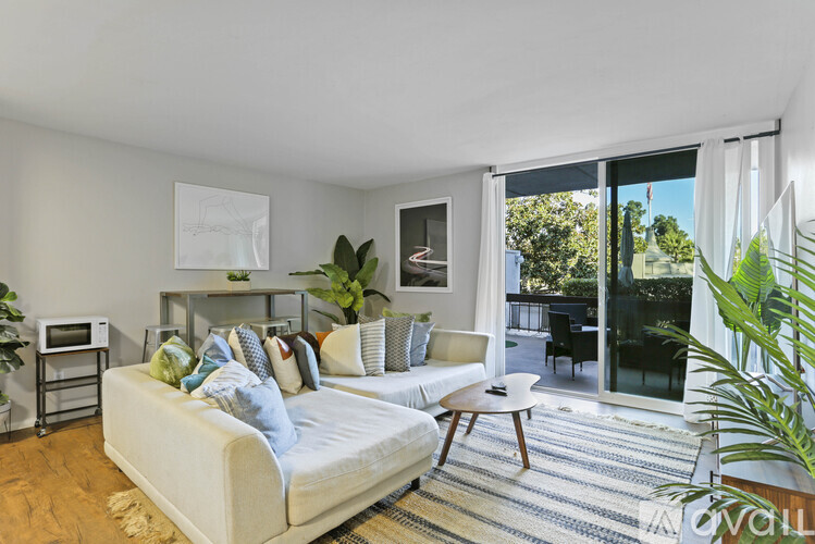 A living room with a white couch and a rug.