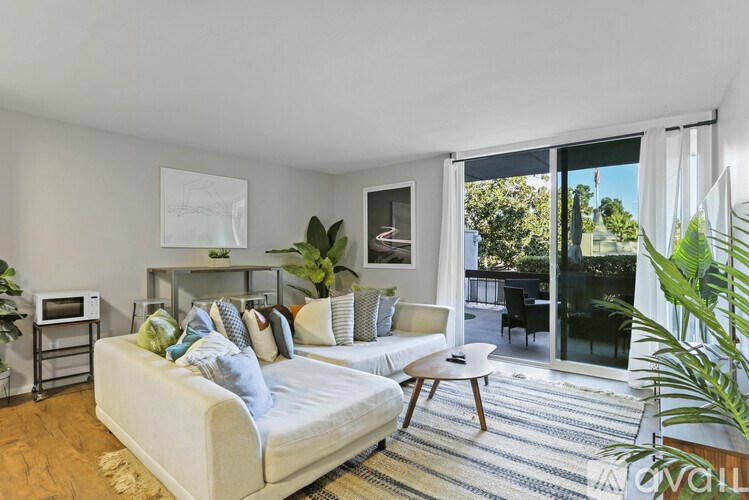 A living room with a white couch and a rug.