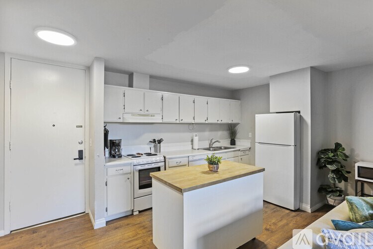 A modern kitchen with white appliances and wooden countertops.