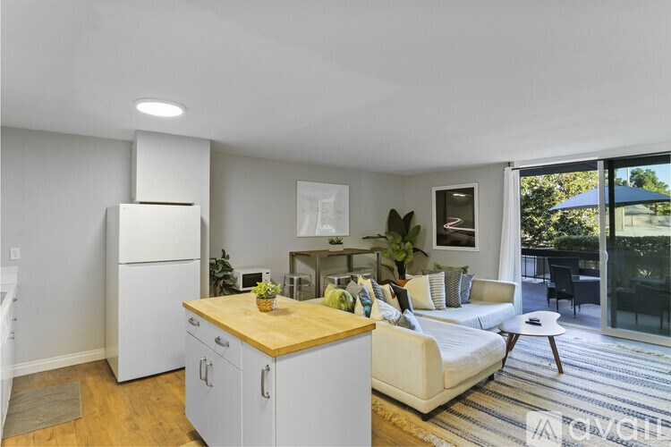 A modern kitchen with white appliances and a wooden island.