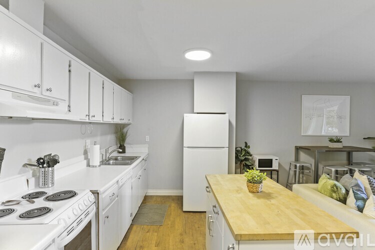 A kitchen with white appliances and a wooden table.