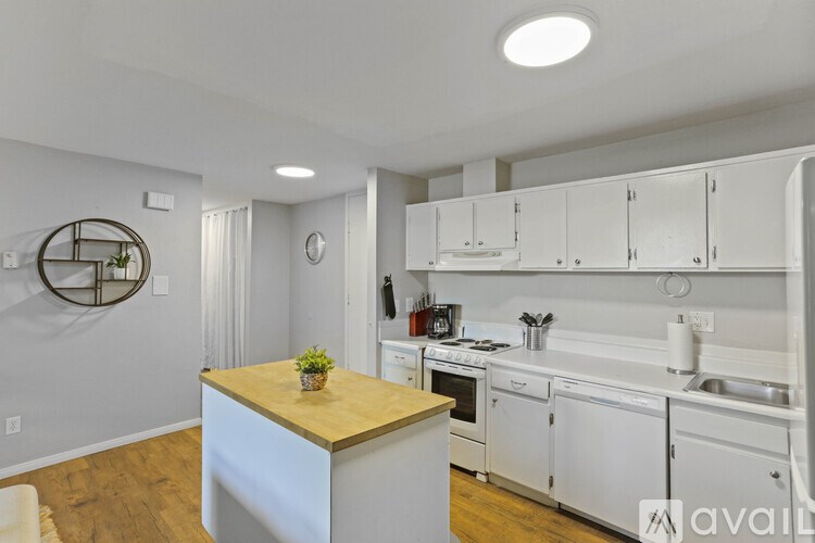 A kitchen with white cabinets and a wooden island.