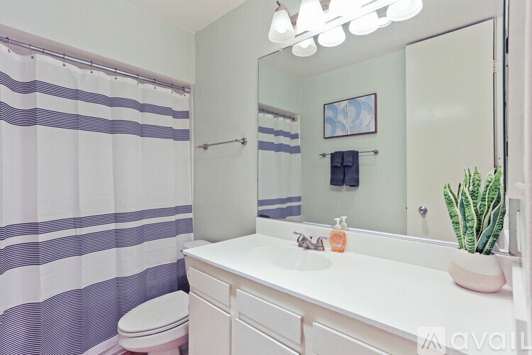 A white bathroom with a toilet, sink, and a mirror.