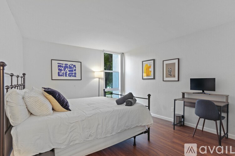 A bedroom with a bed, desk, and chair.