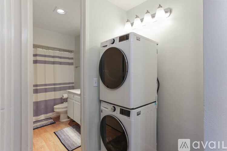 A white washer and dryer stacked on top of each other in a small room.
