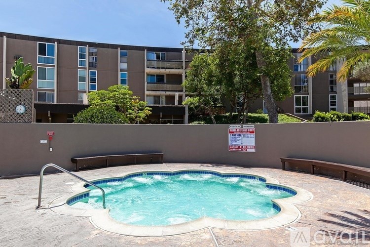 A small pool in front of a building with a sign on the wall.