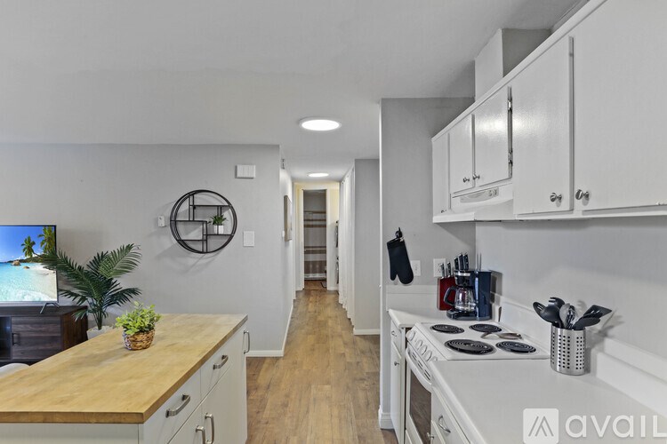 A kitchen with white cabinets and a wooden countertop.