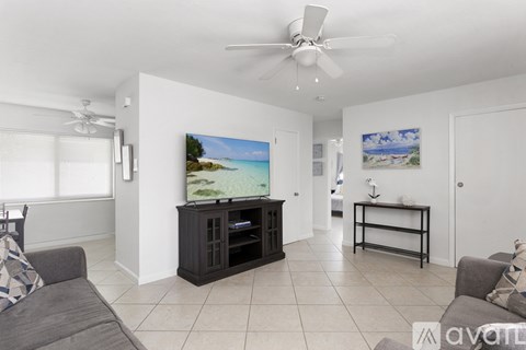 A living room with a grey couch and a television on a wooden stand.