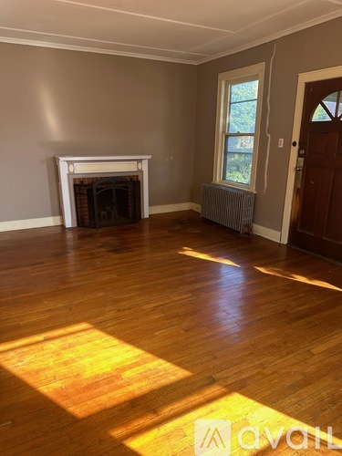 A room with a fireplace and wooden floors.