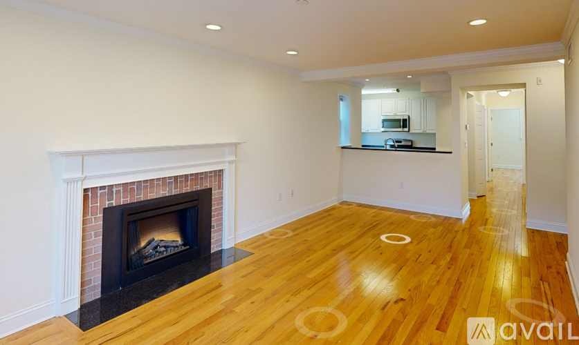 A room with a fireplace and wood flooring.