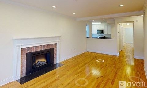 A room with a fireplace and wood flooring.