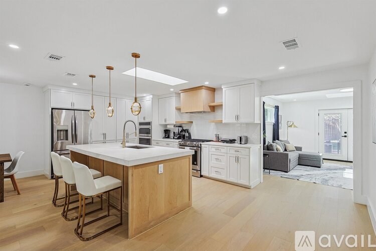 A modern kitchen with wooden floors and white walls.