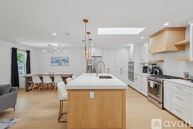 A modern kitchen with a wooden island and white countertops.