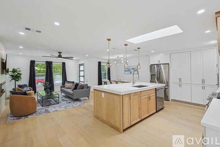 A modern kitchen with wooden floors and white walls.