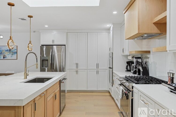 A kitchen with a marble countertop and stainless steel appliances.