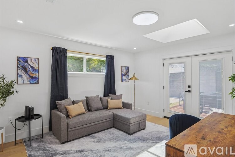 A living room with a grey couch and a wooden table.