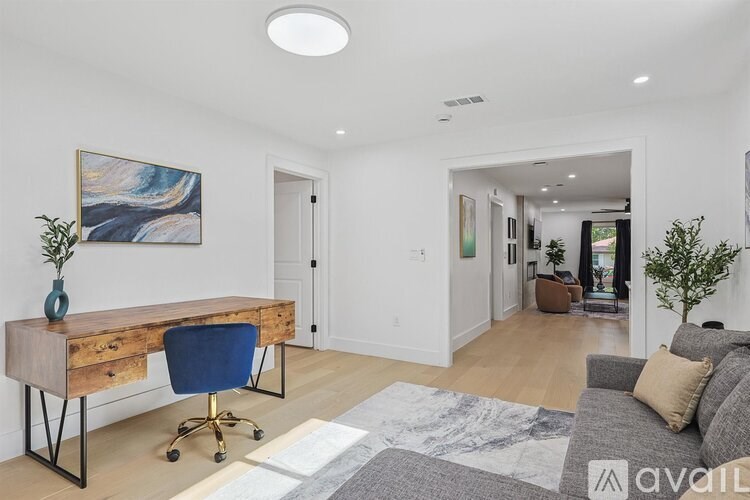 A room with a desk and a chair in it.