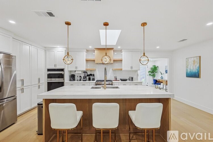 A modern kitchen with white cabinets and a central island.