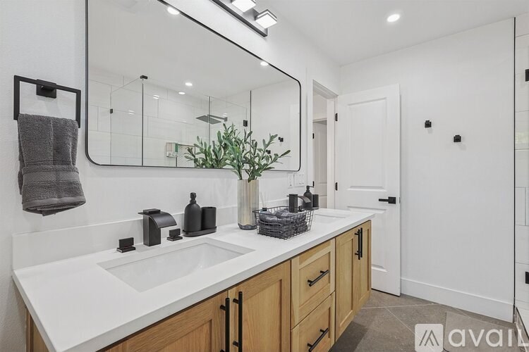 A bathroom with a white countertop and a large mirror.