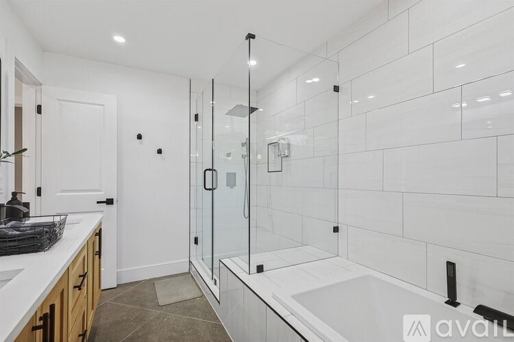 A modern bathroom with a walk-in shower and a sink.
