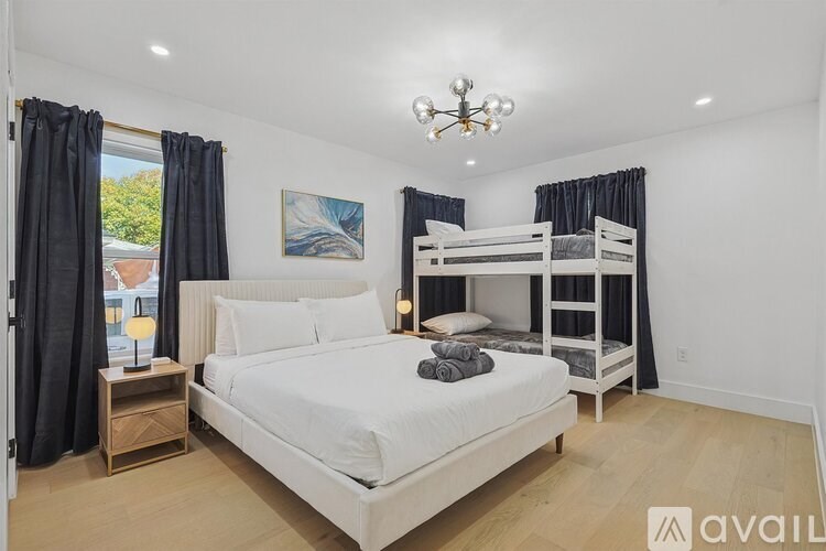 A bedroom with a white bed and a chandelier.