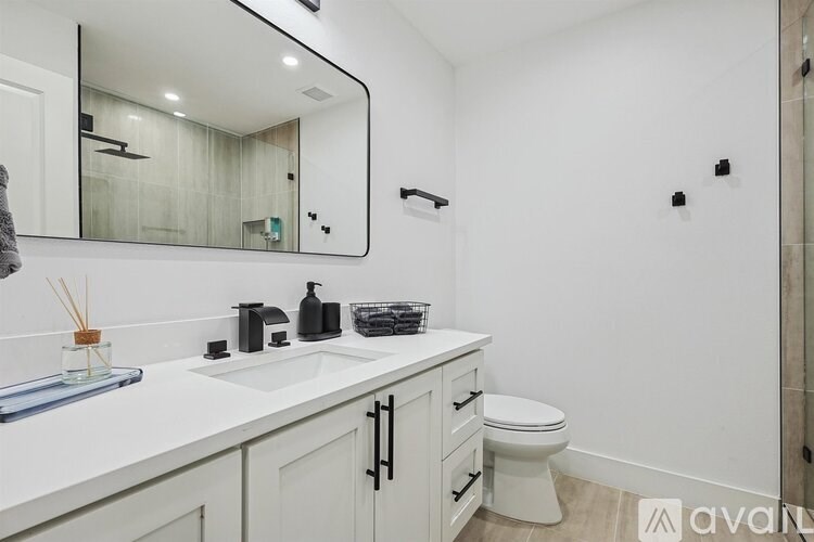 A bathroom with a white sink and toilet.