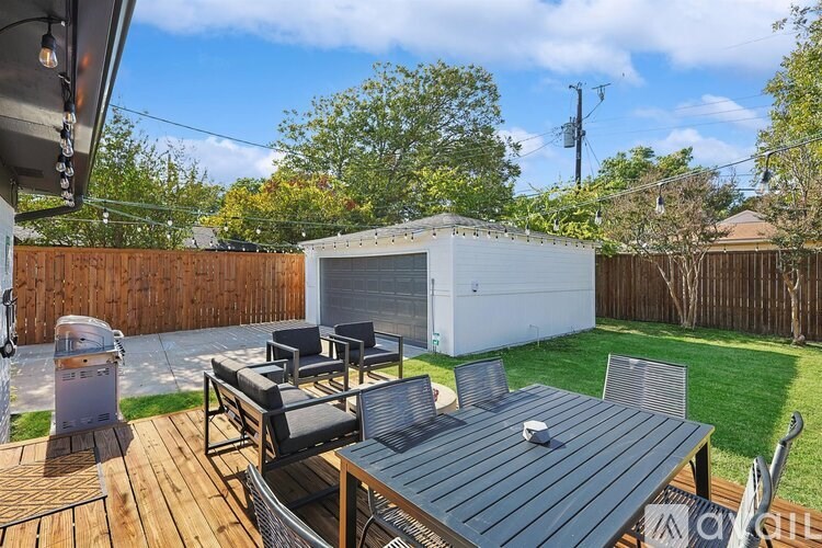 A backyard with a wooden deck and a table.