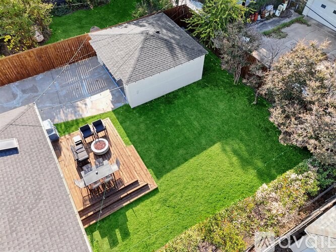 A backyard with a patio and a white building.
