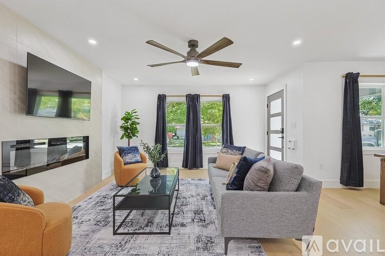 A living room with a ceiling fan, a couch, a chair, and a coffee table.