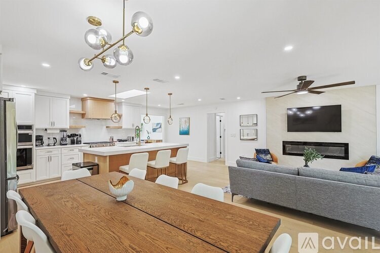 A modern kitchen with a wooden table and chairs.