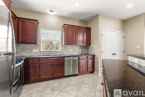 A kitchen with brown cabinets and a marble countertop.