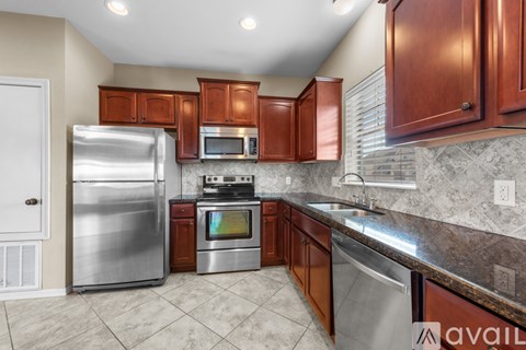 A kitchen with brown cabinets and a stainless steel refrigerator.