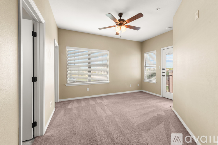 A room with a ceiling fan and carpeted floor.