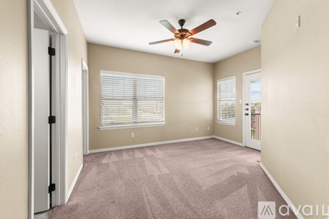 A room with a ceiling fan and carpeted floor.
