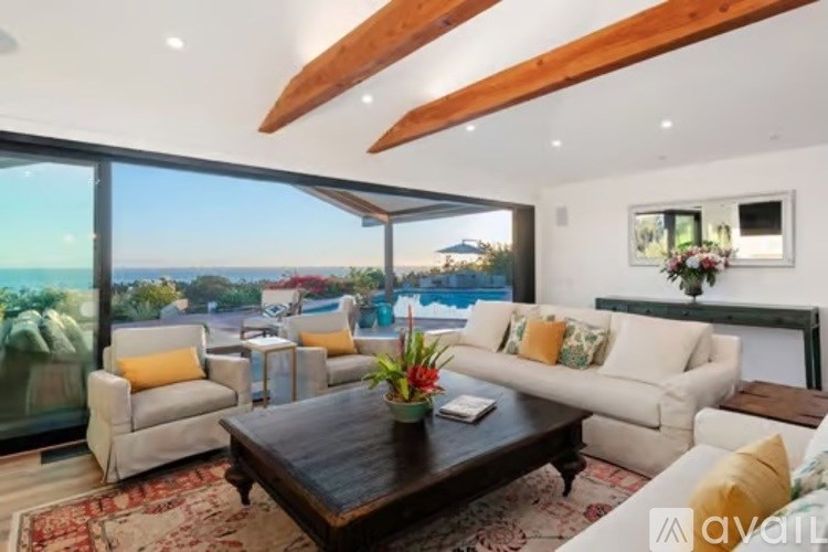A living room with a view of the ocean through large windows.