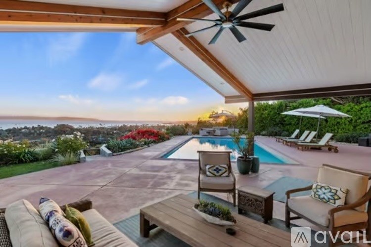 A patio with a pool and a ceiling fan.