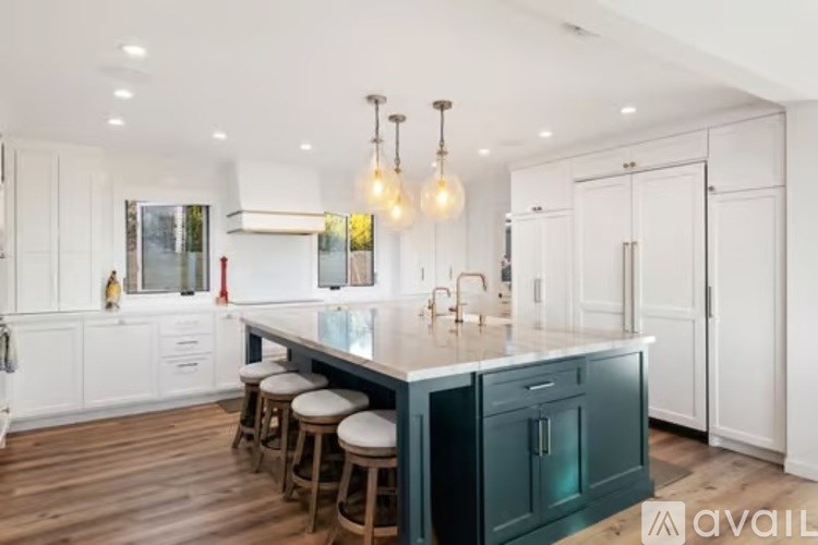 A kitchen with a large island and bar stools.