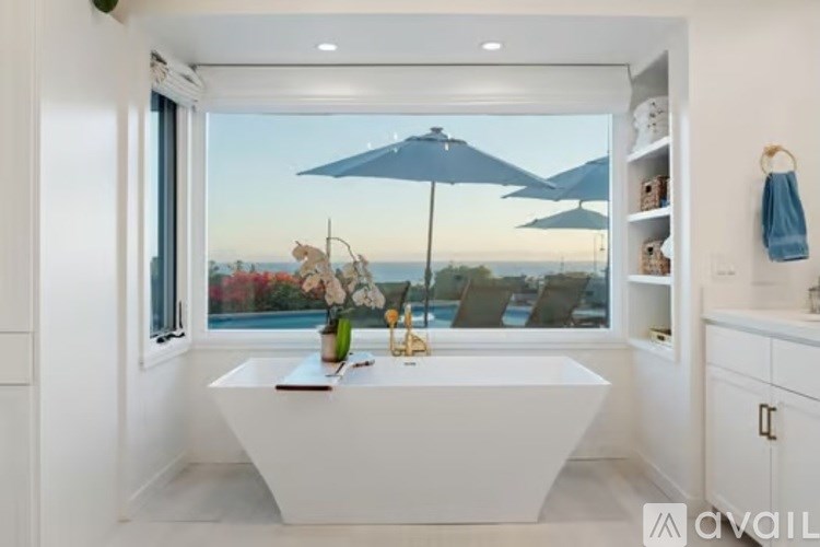 A bathroom with a large window overlooking the ocean.