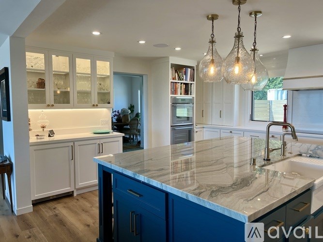 A kitchen with a marble countertop and blue cabinets.