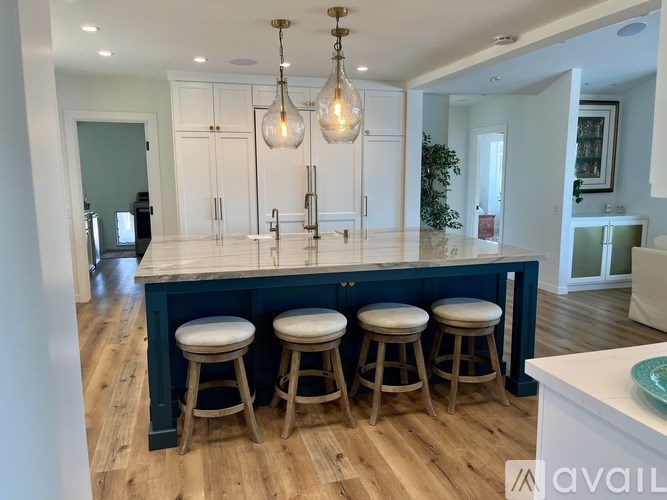 A kitchen with a bar area and stools.