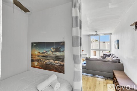 A bedroom with a large bed and a painting on the wall.