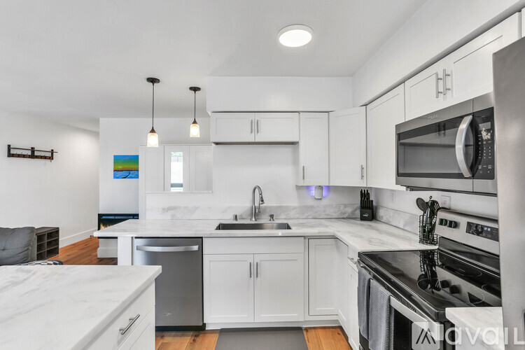A modern kitchen with white cabinets and stainless steel appliances.