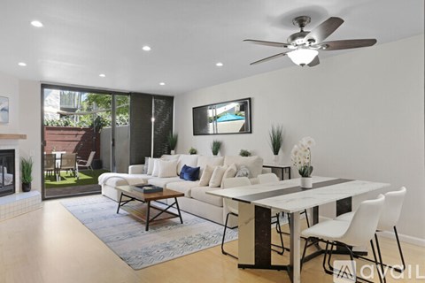 A modern living room with a fireplace and a dining table set up.