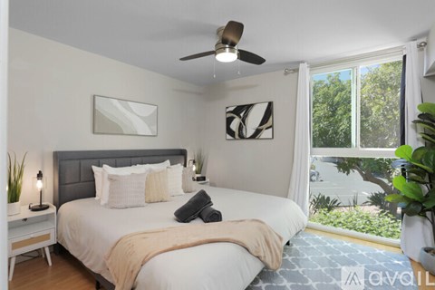 A bedroom with a large bed and a ceiling fan.