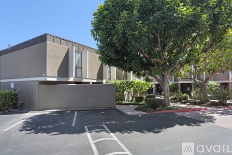 A modern building with a parking lot in front.