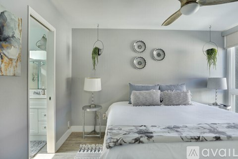 A bedroom with a large bed and a ceiling fan.