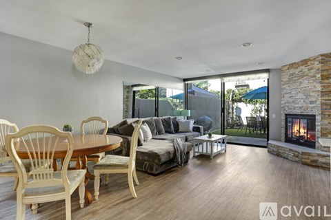 A modern living room with a fireplace and a dining table set up.
