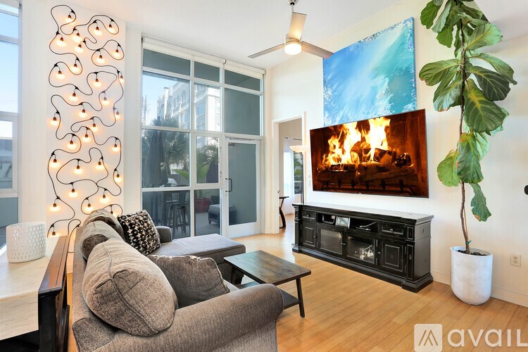 A modern living room with a fireplace and a large painting on the wall.