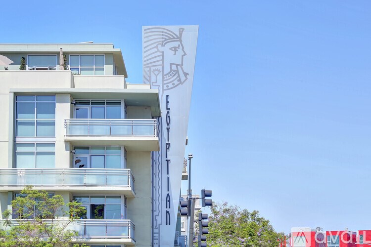 A tall white building with a logo on it.